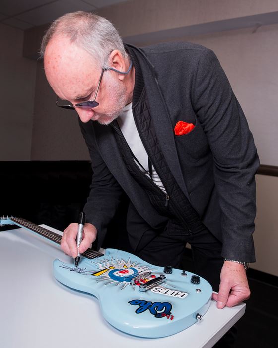 Pete signing guitar