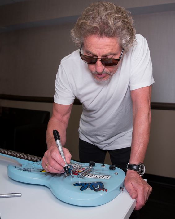 Roger signing guitar
